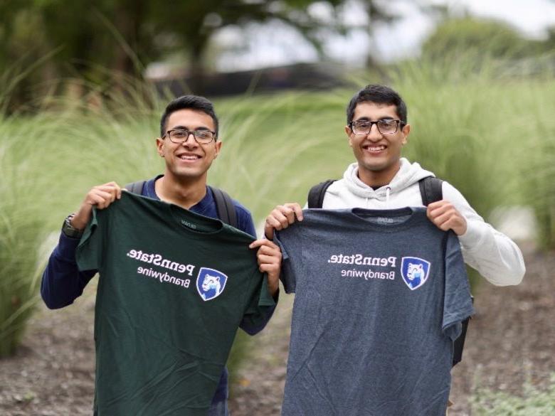 Two male students holding up Penn State Brandywine tee shirts.